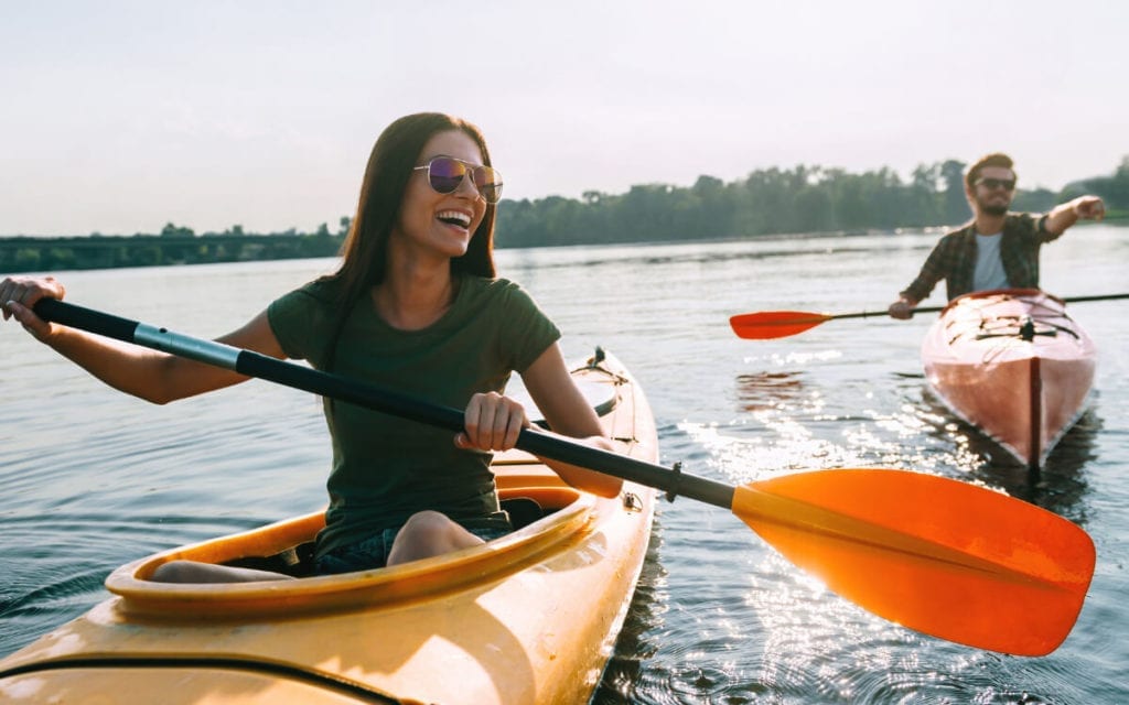 Summer activities, couple kayaking in a lake