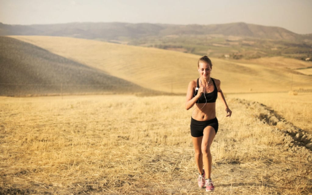 A woman running on a dried grass field