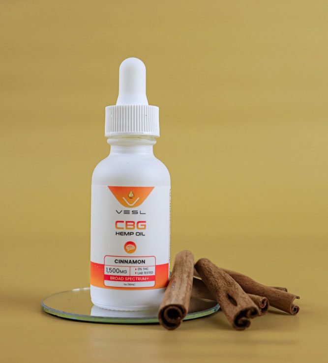 CBG hemp oil cinnamon flavor 1500mg on a display stand with cinnamon sticks